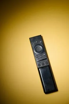 Close-up of a television remote control resting on a table. Stock Photos