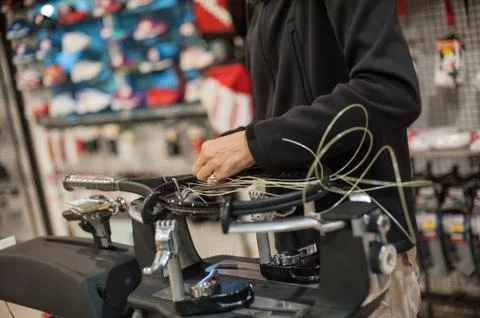 Close up of tennis stringer hands doing racket stringing Stock Photos
