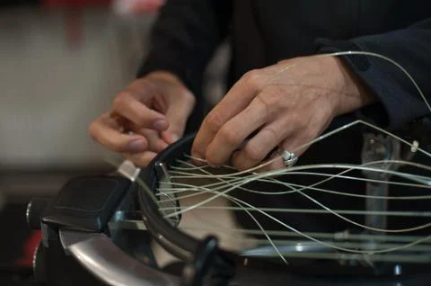 Close up of tennis stringer hands doing racket stringing Stock Photos