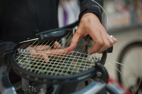 Close up of tennis stringer hands doing racket stringing Stock Photos