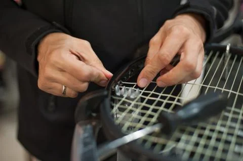 Close up of tennis stringer hands doing racket stringing Stock Photos