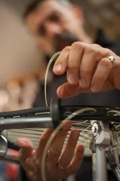 Close up of tennis stringer hands doing racket stringing Stock Photos