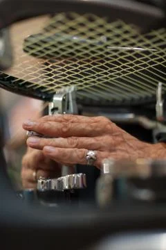 Close up of tennis stringer hands doing racket stringing Stock Photos