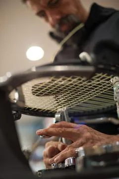 Close up of tennis stringer hands doing racket stringing Stock Photos