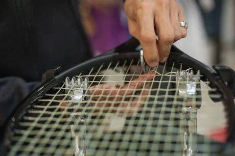 Close up of tennis stringer hands doing racket stringing Stock Photos