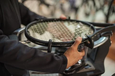Close up of tennis stringer hands doing racket stringing Stock Photos