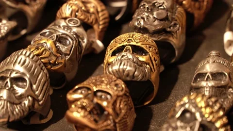 Close-up of terribly gold and silver skull rings. Skull rings that bikers or Video stock 194383615