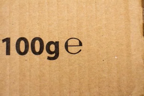 Close-up of text 100g e printed on brown cardboard packaging material Stock Photos