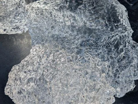 Close-Up Texture of Clear Glacial Ice on Dark Deck Photos