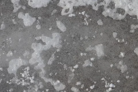 Close-up texture of cracked ice and frost on a dark, gritty surface Stock Photos