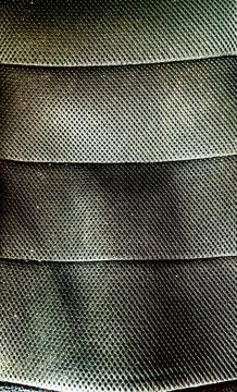 Close-up texture of dark breathable mesh fabric with horizontal layered folds Stock Photos