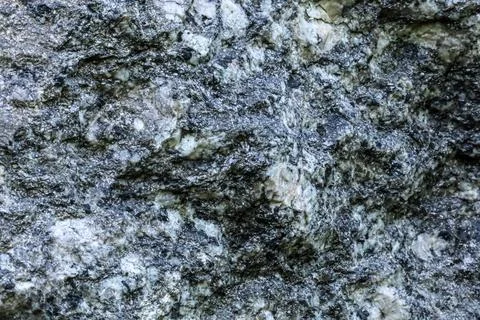 Close-up texture of a dark gray and white speckled granite rock surface Stock Photos
