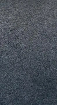Close-up texture of dark grey rough stone surface. Stock Photos