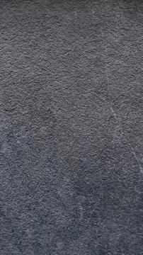 Close-up texture of a dark grey stone surface. Stock Photos