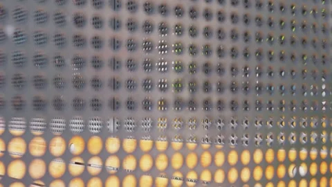Close-up texture of a gray metallic grid pattern featuring circular holes Vidéo 337153694