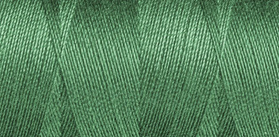 Close-up texture of green sewing threads on a spool Stock Photos