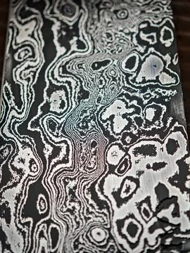 Close-up texture of a hand-forged damascus steel blade with unique wavy pat.. Stock Photos
