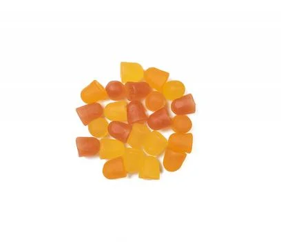Close-up texture of orange and yellow multivitamin gummies on white backgroun Stock Photos
