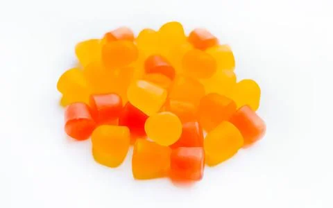 Close-up texture of orange and yellow multivitamin gummies in the form of bears Stock Photos