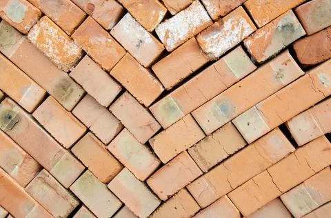 Close up texture of piled bricks. Background from red bricks stacked on top. Stock Photos