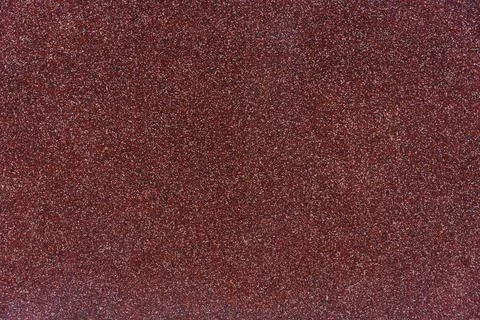 Close-up texture of red granular roofing surface with mineral coating for Stock Photos