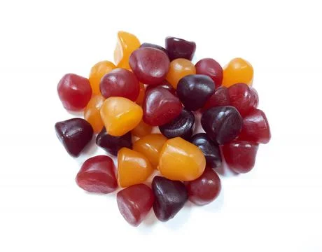 Close-up texture of red, orange and purple multivitamin gummies on white back Stock Photos