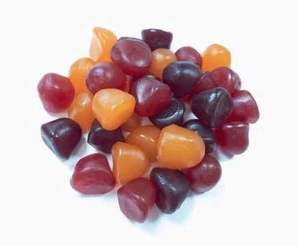 Close-up texture of red, orange and purple multivitamin gummies on white back Stock Photos