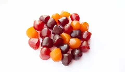 Close-up texture of red, orange and purple multivitamin gummies on white Stock Photos