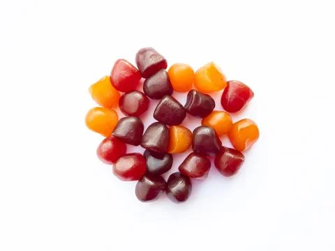 Close-up texture of red, orange and purple multivitamin gummies on white Stock Photos