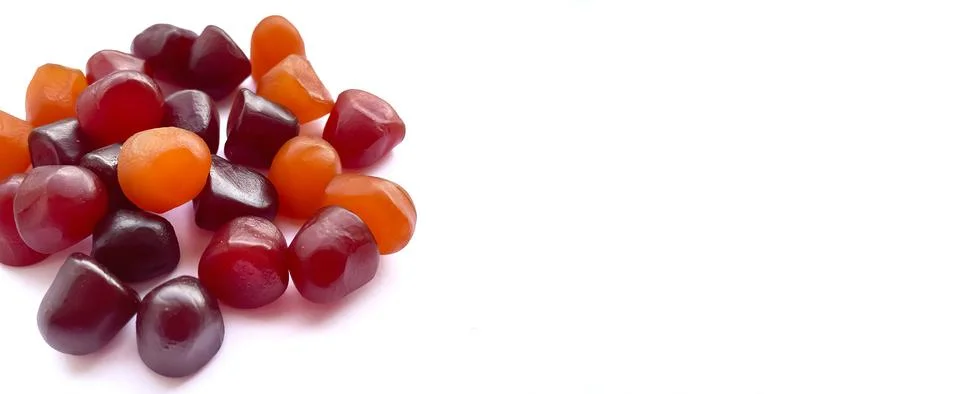 Close-up texture of red, orange and purple multivitamin gummies on white Stock Photos