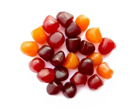 Close-up texture of red, orange and purple multivitamin gummies on white Stock Photos