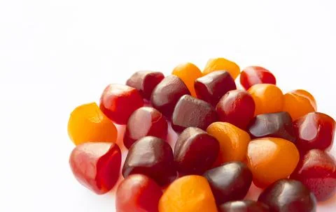 Close-up texture of red, orange and purple multivitamin gummies on white Stock Photos