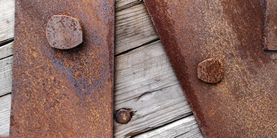 Close up texture of rusty iron sheets bolted to aged wooden planks Foto stock