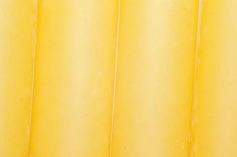 Close-up texture of sliced yellow cheese showing subtle imperfections and s.. Stockfoto's