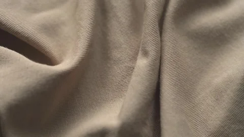 A close-up texture of soft wrinkled beige jersey fabric Stock Footage 340022219