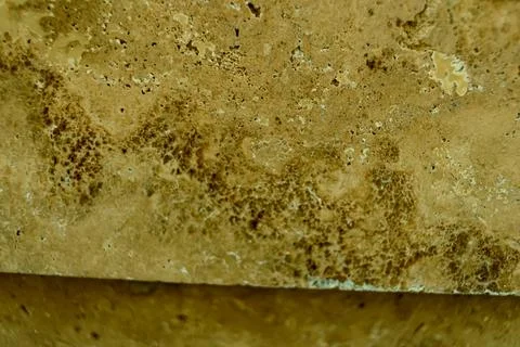 Close-up texture of a stained stone surface with brown discoloration and porous Stock Photos