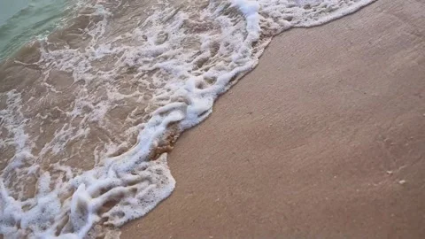 Close-up texture of the surface of a sea or ocean wave that comes to the sandy Stock Footage 158580062
