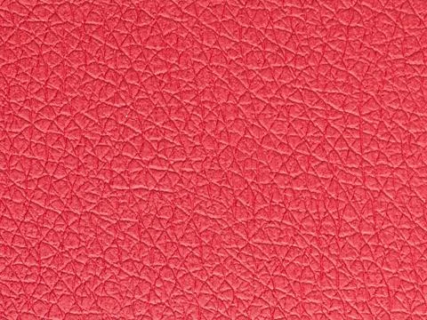 Close-up texture of vibrant coral red pebbled leather grain Stock Photos
