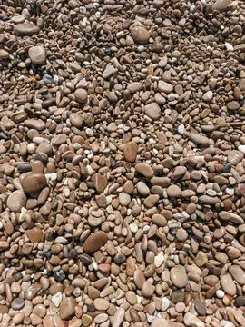 Close-up texture of washed brown pebbles on Cap d'Ail coastline Stock Photos
