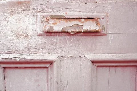 Close-up texture of a weathered peeling pink painted wooden door Фото