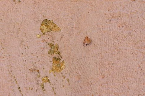 Close-up texture of a weathered pink stucco wall with peeling paint and sub.. Stock Photos