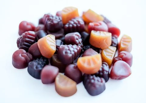 Close-up texture of yellow and brown multivitamin tablets in form of fruits on Stock Photos