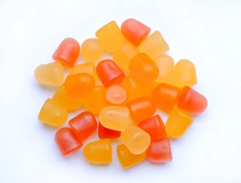 Close-up texture of yellow and orange multivitamin tablets on white background Stock Photos