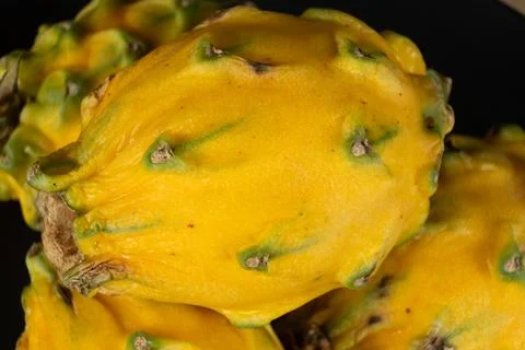 Close-up texture of yellow dragon fruit skin on black background 写真素材