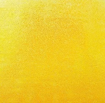 Close-up texture yellow embossed paper glossy shimmering with halo effect Foto stock