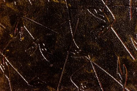 Close-up of a texture of yellow glass with a pattern of leaves and branches 写真素材