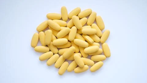 Close-up texture of yellow multivitamin tablets on white background. Healthy Stock Photos