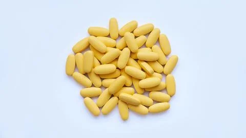 Close-up texture of yellow multivitamin tablets on white background. Healthy Stock Photos