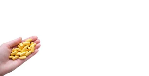 Close-up texture of yellow multivitamin tablets in female hand on white Stock Photos