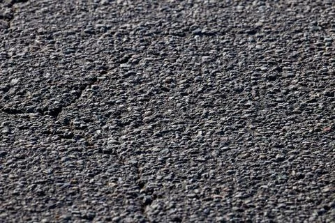 Close Up of Textured Asphalt Surface with Visible Cracks and Pebbles Stock Photos